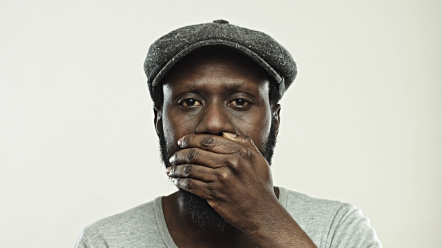 Real black mature man covering eyes, ears and mouth with hands